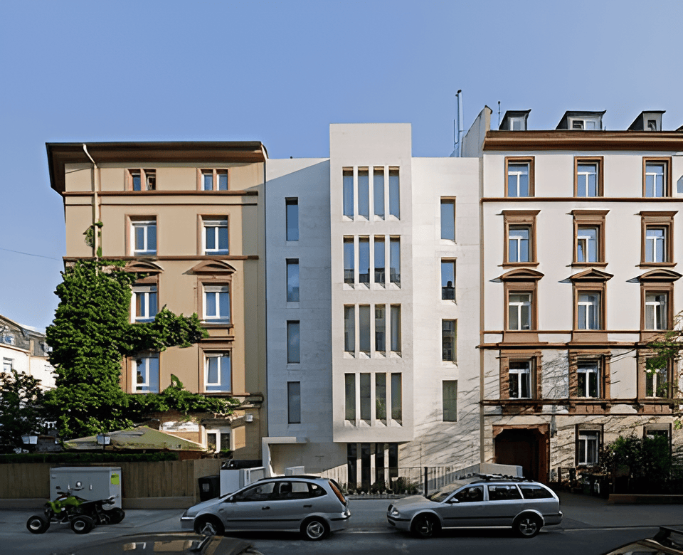 Modern natural stone facade of a new building between two historic buildings