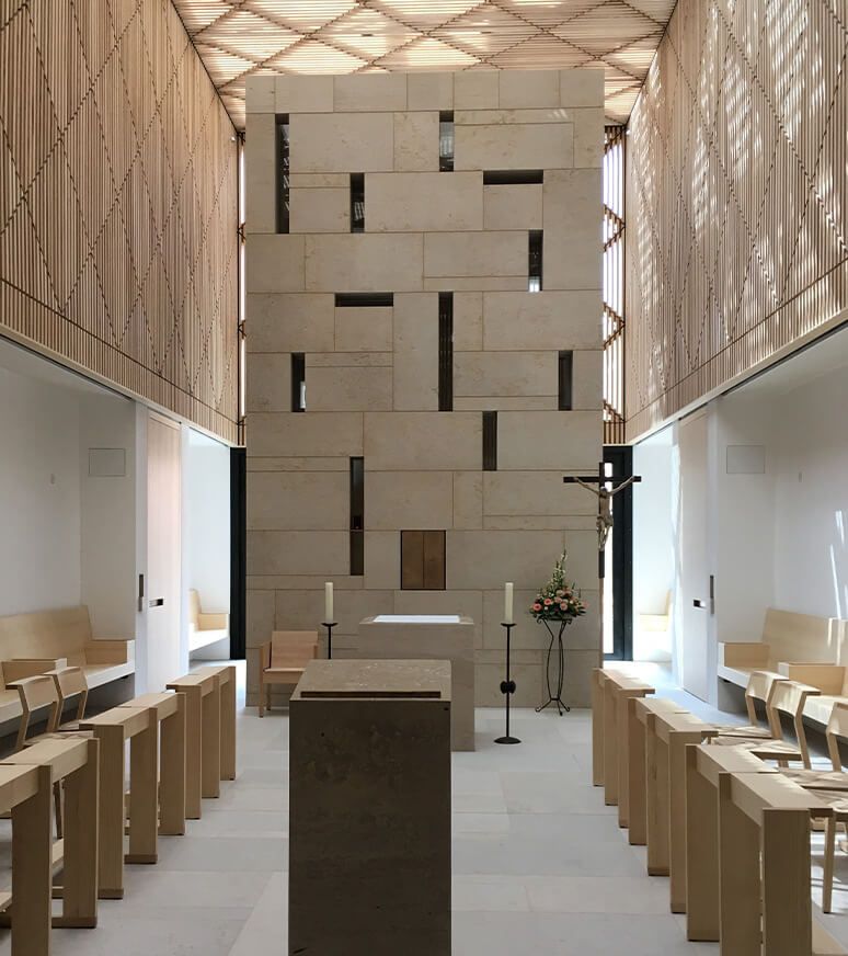 Modern chapel with natural stone wall and delicate wooden ceiling structure