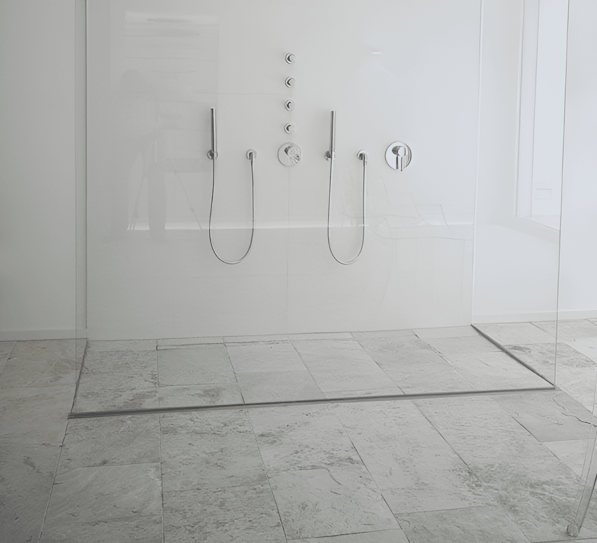 Barrier-free, minimalist shower with natural stone floor and glass partition